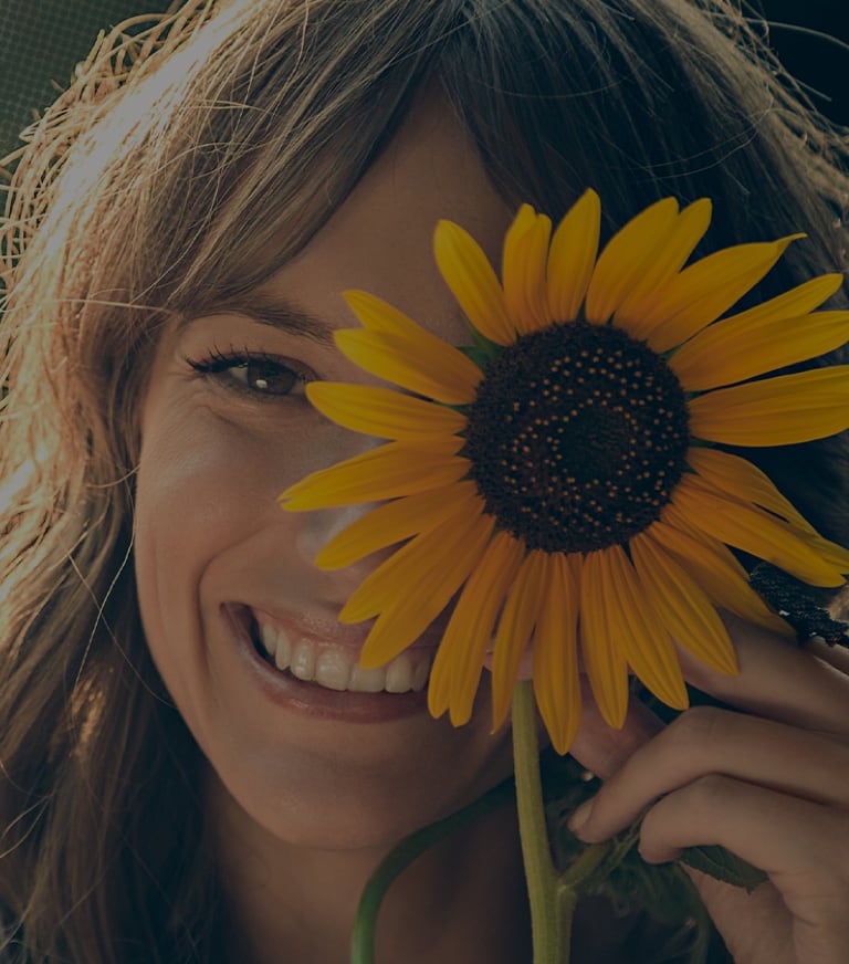 Orillia Optometry woman smiling with sunflower