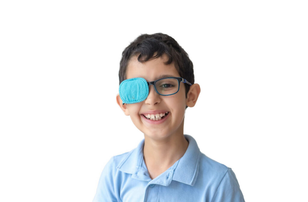 A portrait of a boy smiling big with a patch on his eyeglasses. Eye patch for glasses to treat lazy eye.