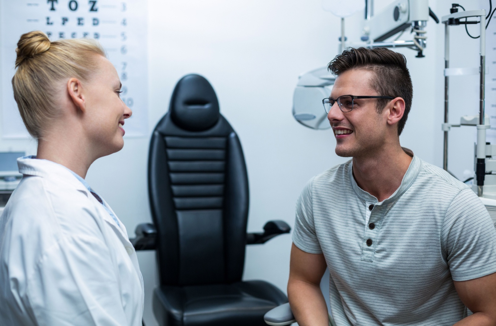An optometrist talking to her patient in an exam room
